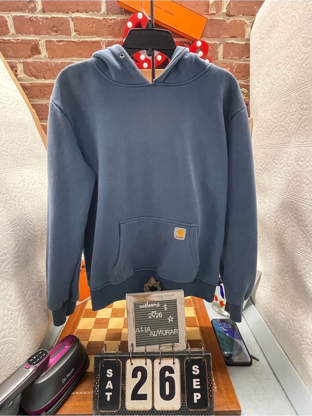 blue Carhartt pullover hoodie featuring a front kangaroo pocket accented